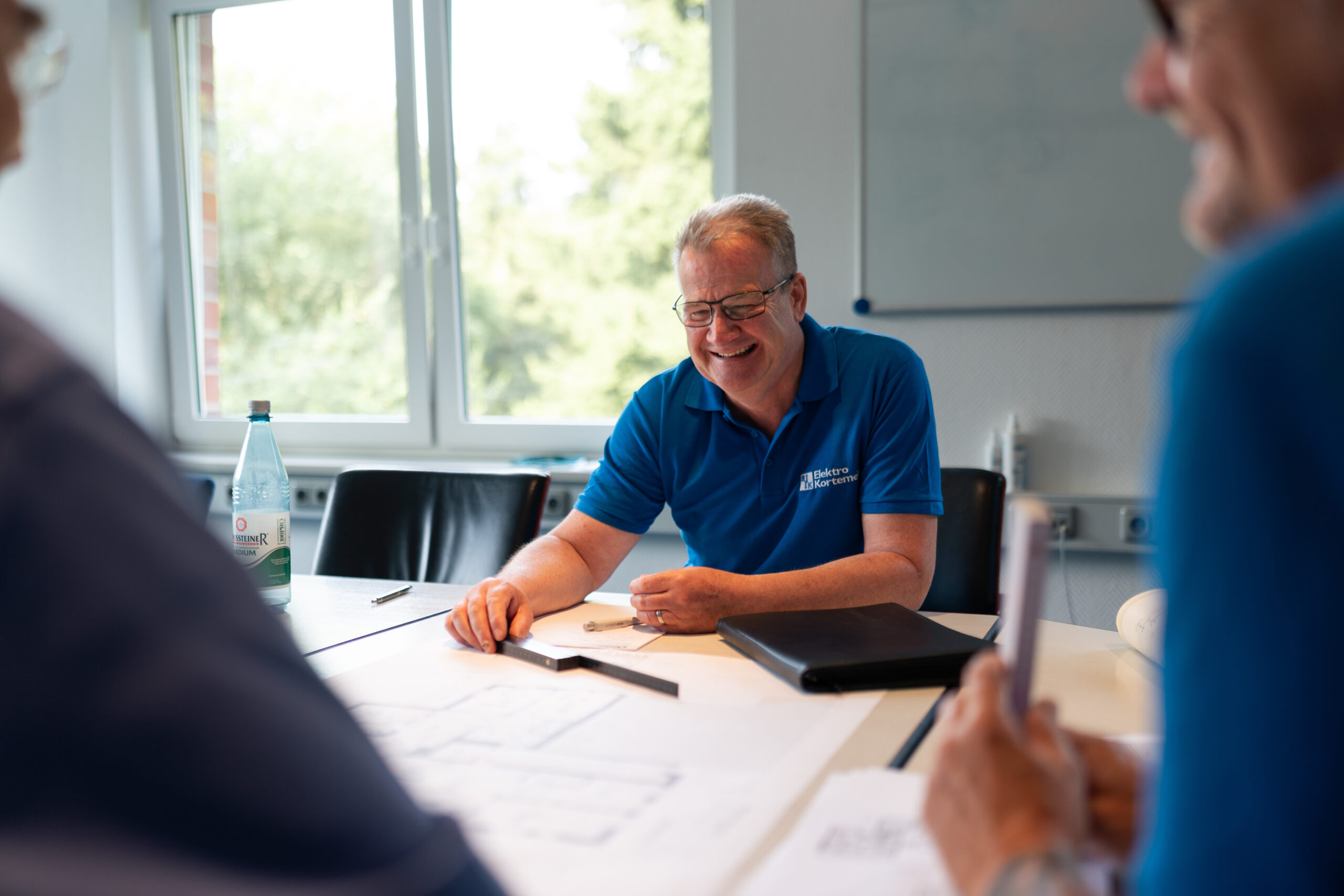 Ein Mitarbeiter am Tisch, vor ihm liegt ein Plan